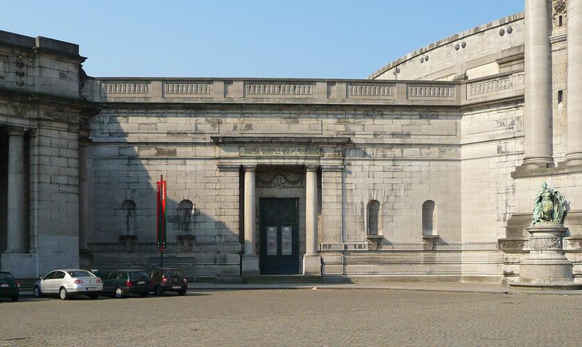 Verbindingsmuur tussen de triomfboog van het Jubelpark en de grote zuidelijke hal, in 1909 ontworpen door Charles Girault met een deuropening die vandaag wordt gebruikt als bijkomende ingang van de Koninklijke Musea voor Kunst en Geschiedenis (foto 2010).