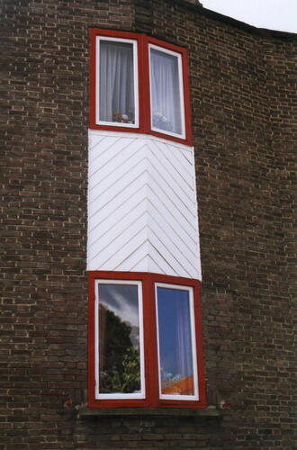 Perspectieflaan 2, detail van enige in Sint-Pieters-Woluwe nog bewaarde eterniet <a href='/nl/glossary/39' class='info'>borstwering<span>1. Verhoogd gedeelte van een vestingsmuur waarachter men veilig kan lopen; - 2. Muurtje of hekwerk (balkon, terras); - 3. Deel van een muur tussen vloer en onderzijde van een venster; - 4. Verhoging van de buitenmuren van een huis boven de zolderbalken waarop een muurplaat rust.</span></a> (foto 2006).
