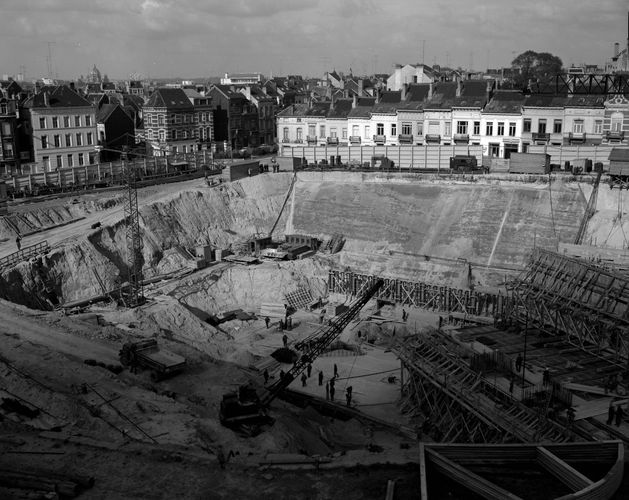 Excavation en vue de l'édification du Berlaymont, avec à l'arrière-plan les petites maisons de la rue Stevin, 1963 (© Régie des Bâtiments). 