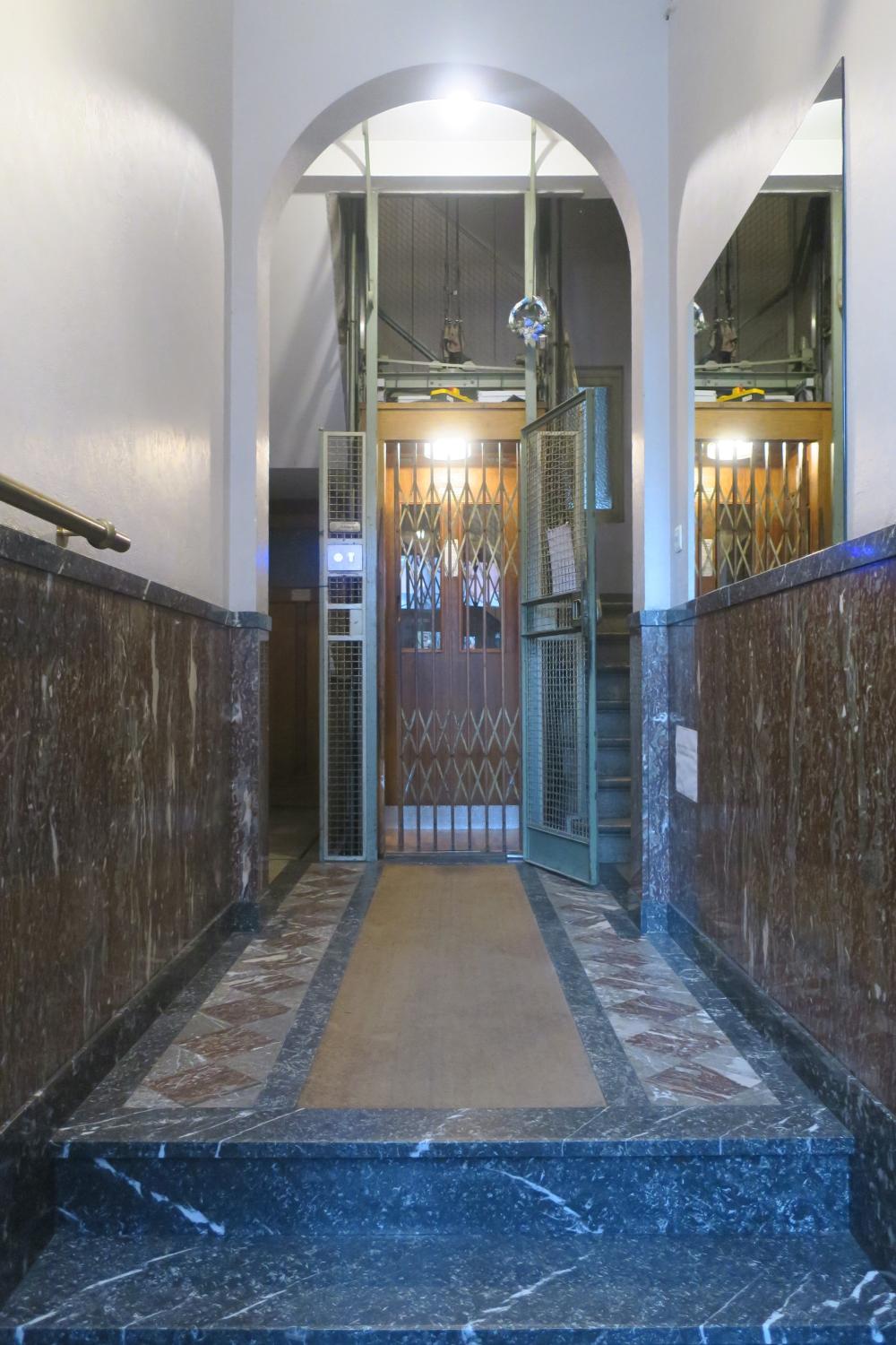 Rue de la Consolation 73. Ascenseur au rez-de-chaussée avec porte palière ouverte © Homegrade, 2023
